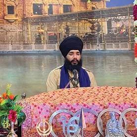 Bhai Sahib seated in kirtan beside the sarovar