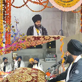 Bhai Sahib addressing the sangat from a flower-decorated stage